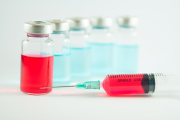 Red liquid in injection syringe and vials