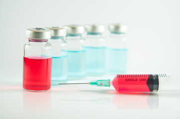 Red liquid in injection syringe and vials