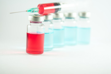 Red liquid in injection syringe and vials