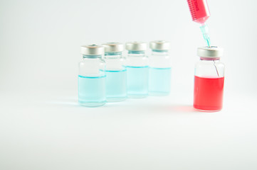 Red liquid in injection syringe and vials