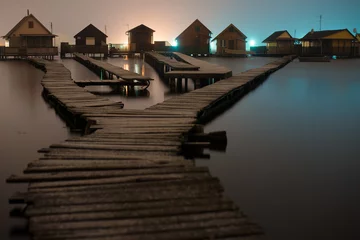 Papier Peint photo Jetée Magnificent long exposure lake at night with fishing houses