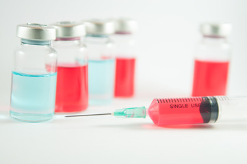 Red liquid in injection vials and syringe