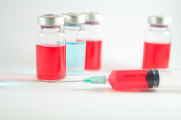 Red liquid in injection syringe and vials