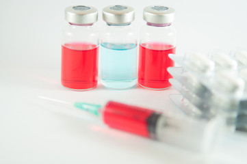 Red liquid in injection syringe and vials