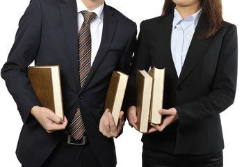 難しい本を読んで調べている男女の二人のビジネスマン