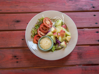 fruit salad with cream in dish on the wooden table