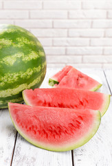 Juicy watermelon on table on brick wall background