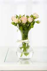 Beautiful bouquet of flowers in vase on window background