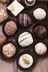Many chocolates on wooden textured background