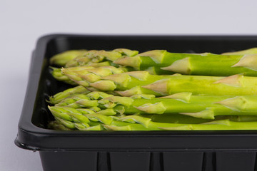Fresh asparagus in black tray