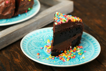 Chocolate cake with colorful sweet powder on table close-up