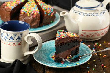 Chocolate cake with colorful sweet powder on table close-up