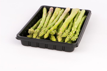 Fresh asparagus in black tray