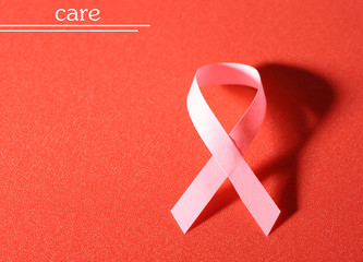 Pink breast cancer ribbon on red background