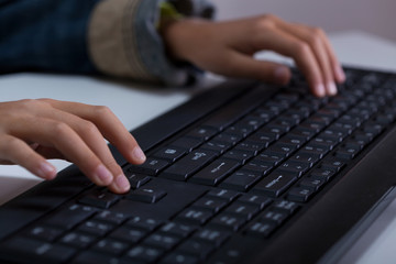 Boy's hands typing on keyboard