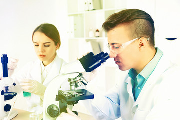 Young male researcher carrying out scientific research in lab