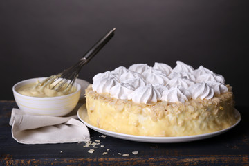 Tasty homemade meringue cake on wooden table, on grey