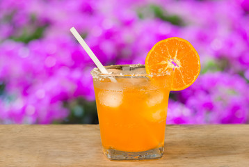 Glass of orange juice and fresh orange  on wooden table,pink bok