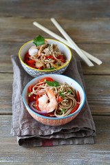 Two portions of noodles with shrimp in a bowl