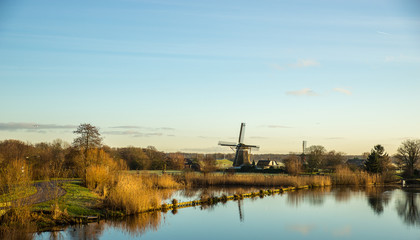 Fototapeta na wymiar Landscape with windmill and river
