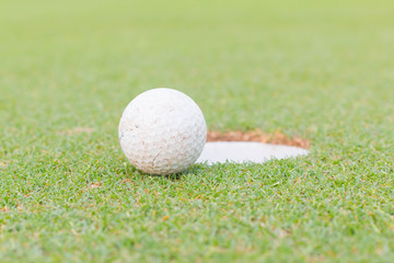 golf ball on lip of cup