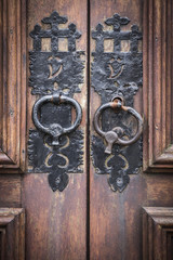 handles of an ancient brown wooden door