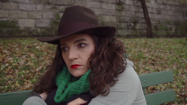 Sad woman sitting in park, closeup, steadycam, slow motion shot 