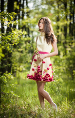Fototapeta na wymiar Young beautiful girl in a yellow dress in the woods