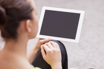 Back View Portrait of Woman Holding Tablet Computer. Focus on Ta