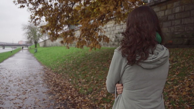 Woman walking on boulevard on gloomy day, steadycam, slow motion