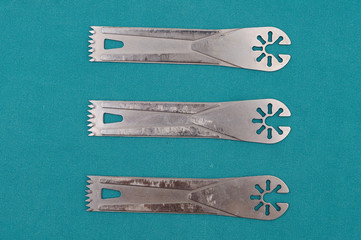 Surgery oscillating saw blades on green cloth.