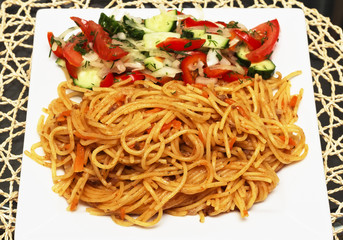 Tomatoa pasta on plate with fresh basil leaves
