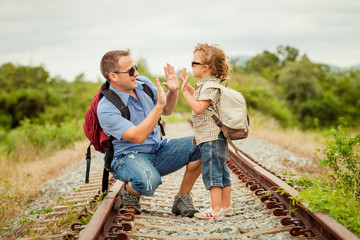 Happy family walking on the railway at the day time.