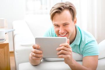 Man with gadget sitting at home
