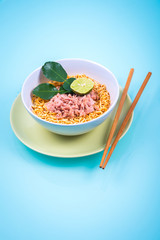 Asian tomyam noodle with tuna and lime in blue background