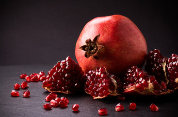 Some red pomegranates on black slate plate