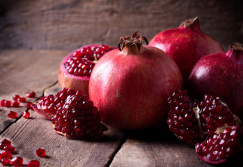 Some red pomegranates on old wooden table