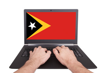 Hands working on laptop, East Timor