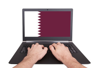 Hands working on laptop, Qatar