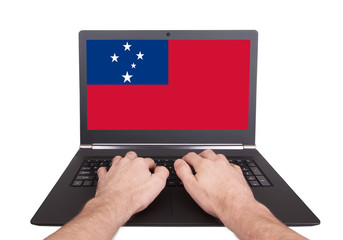 Hands working on laptop, Samoa