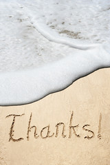 Conceptual thank you text in sand and water