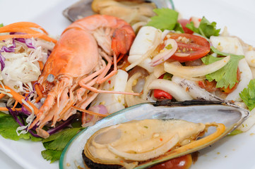 Mixed spicy sea-food salad on white plate