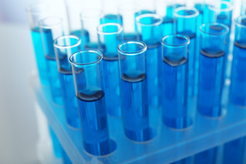 Blue water in a transparent test-tube on light background