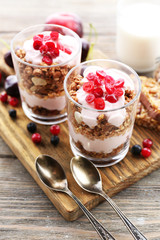 Healthy layered dessert with muesli and berries on table