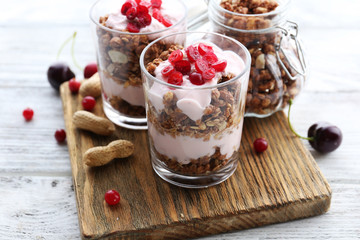 Healthy layered dessert with muesli and berries on table