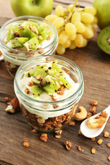 Healthy layered dessert with muesli and fruits on table