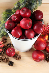 Christmas apples in bucket on wooden table