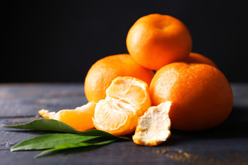 Fresh ripe mandarins on wooden table, on dark  background