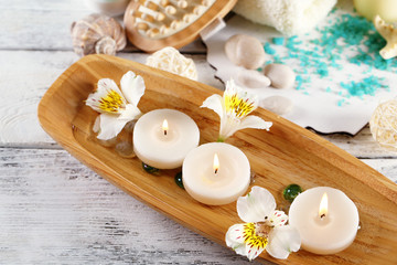 Composition of spa treatment, candles in bowl with water