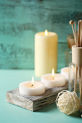 Candles, bottles sea salt and spa stones on wooden background
